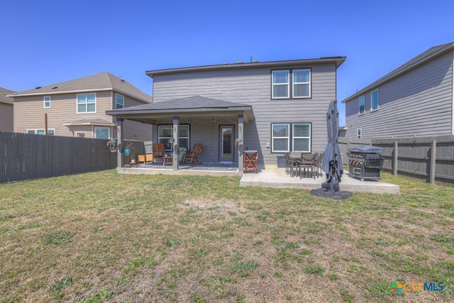 back of property featuring a yard, a patio area, and a fenced backyard