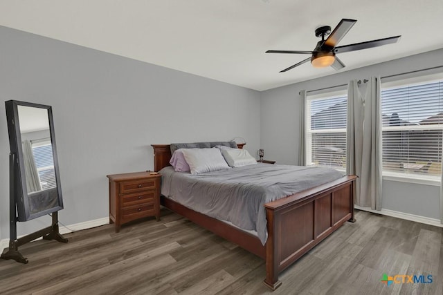 bedroom with multiple windows and wood finished floors