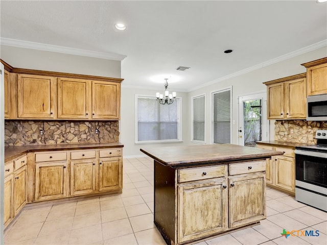 kitchen with appliances with stainless steel finishes, ornamental molding, a notable chandelier, and light tile patterned flooring