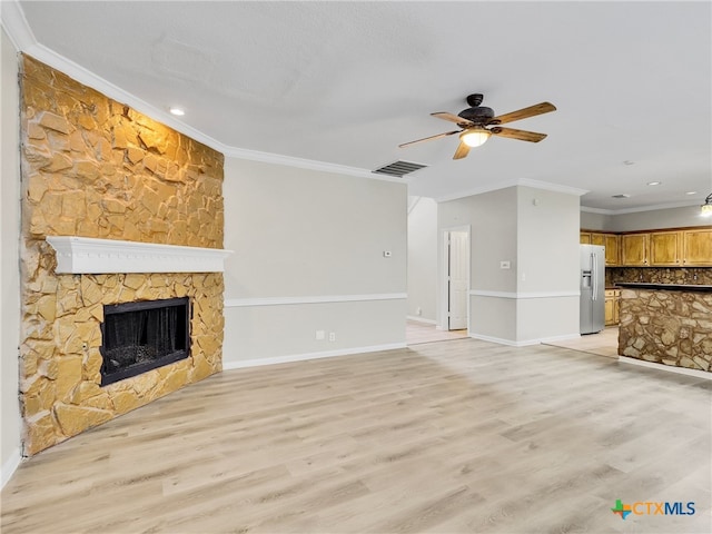 unfurnished living room with ceiling fan, ornamental molding, a fireplace, and light hardwood / wood-style flooring