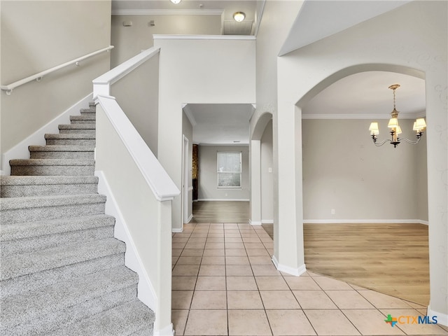 entrance foyer with light hardwood / wood-style flooring, an inviting chandelier, and ornamental molding