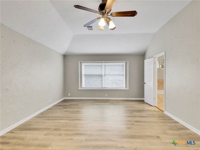 empty room with ceiling fan, light hardwood / wood-style flooring, and lofted ceiling