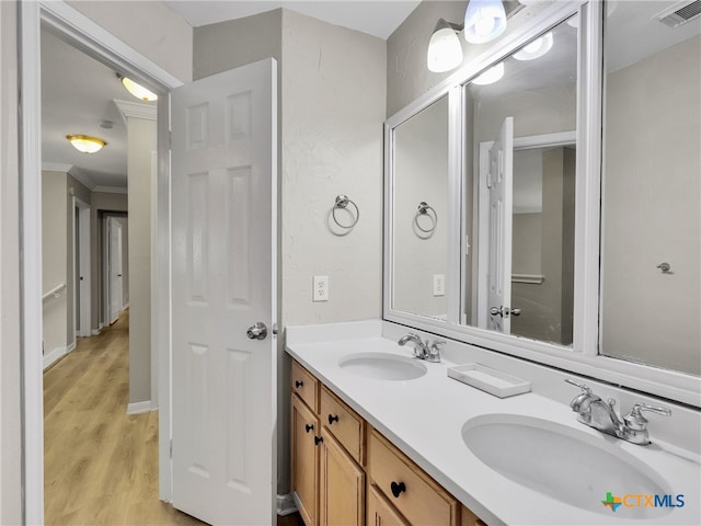 bathroom featuring crown molding, vanity, and wood-type flooring