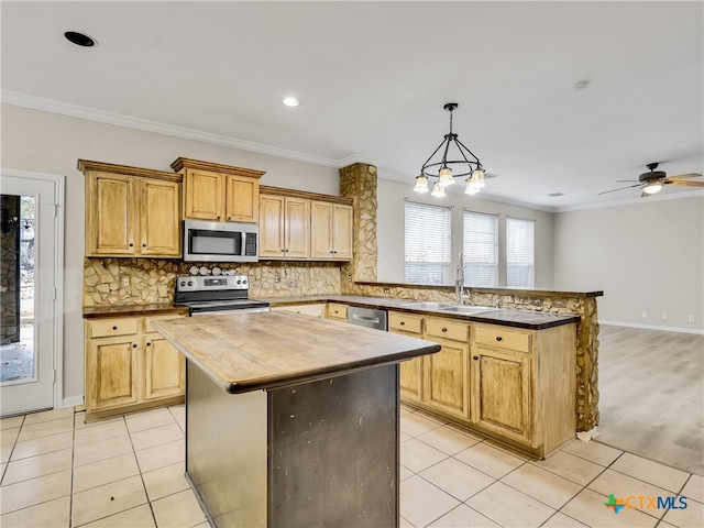 kitchen with a center island, ceiling fan with notable chandelier, crown molding, sink, and stainless steel appliances