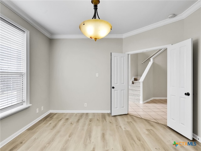 unfurnished room featuring light hardwood / wood-style floors and crown molding