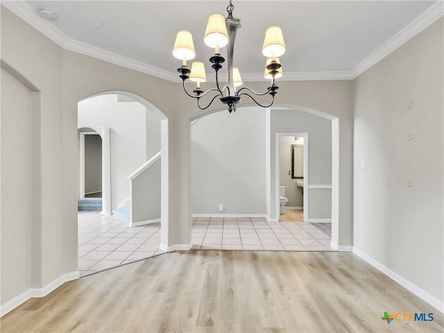 unfurnished dining area with a notable chandelier, ornamental molding, and light hardwood / wood-style flooring