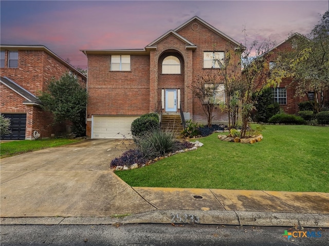 view of property with a garage and a lawn