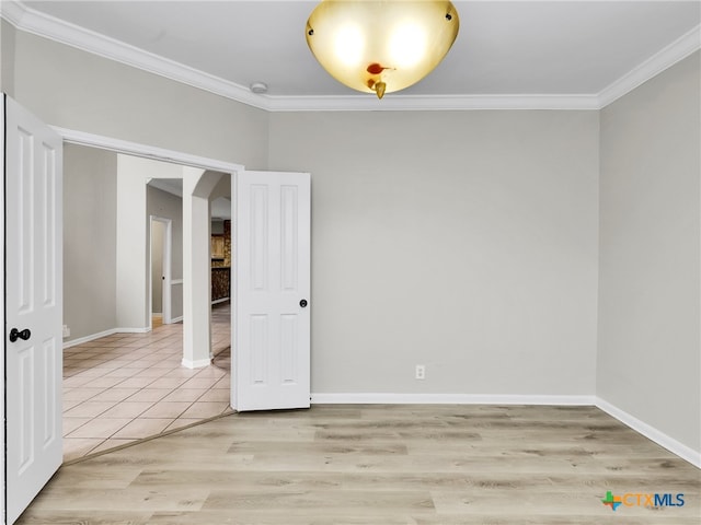 spare room featuring light wood-type flooring and ornamental molding