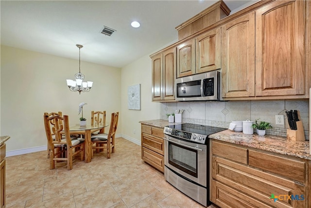 kitchen featuring pendant lighting, decorative backsplash, light stone countertops, appliances with stainless steel finishes, and a notable chandelier