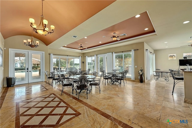 dining room featuring french doors, ceiling fan with notable chandelier, a raised ceiling, and lofted ceiling