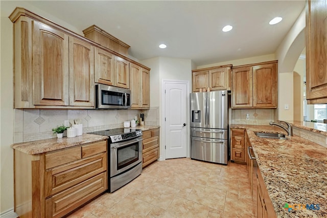 kitchen featuring decorative backsplash, sink, and appliances with stainless steel finishes