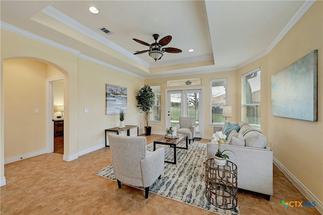 living room with ceiling fan, crown molding, and a tray ceiling