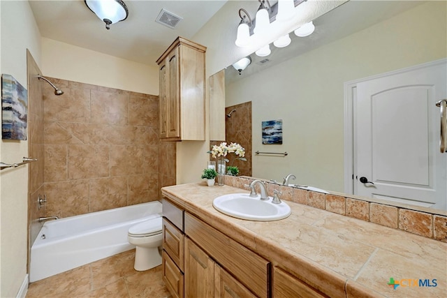 full bathroom featuring tile patterned floors, tiled shower / bath combo, toilet, and vanity