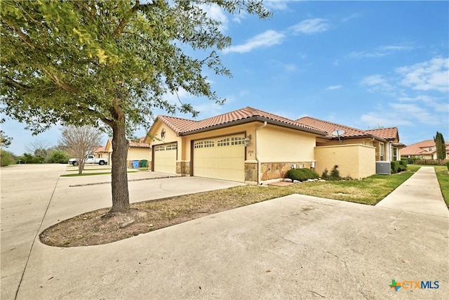 mediterranean / spanish home with a garage and cooling unit