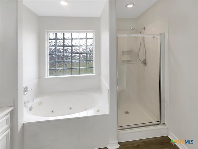 bathroom featuring hardwood / wood-style flooring, vanity, and shower with separate bathtub