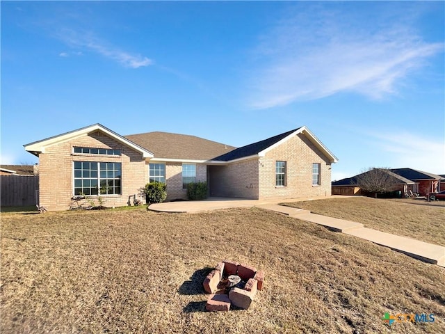 ranch-style house featuring a front lawn and a patio