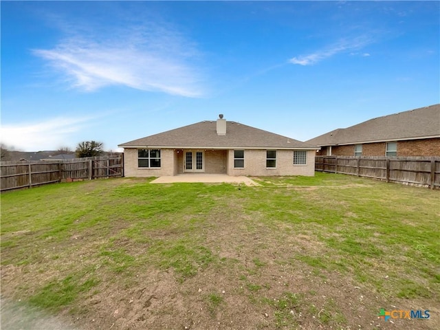 back of house with a lawn and a patio