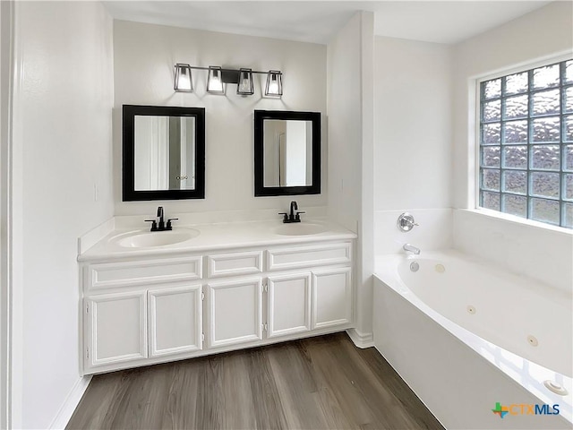 bathroom featuring vanity, hardwood / wood-style flooring, and a bathtub