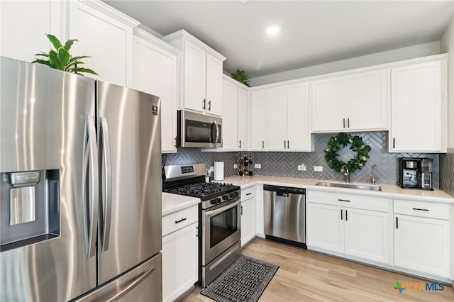 2024 Cowan Dr, New Braunfels, TX 78132 - kitchen featuring stainless steel appliances, light countertops, white cabinets, tasteful backsplash, and recessed lighting