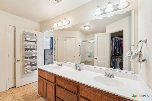 full bathroom featuring tile patterned flooring, a stall shower, visible vents, and a sink