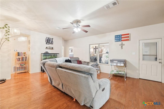 living room with visible vents, a ceiling fan, and light wood-style floors