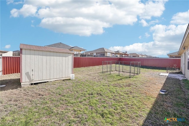 view of yard with a storage unit, a fenced backyard, and an outdoor structure