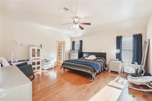 bedroom with visible vents, lofted ceiling, a ceiling fan, and light wood finished floors