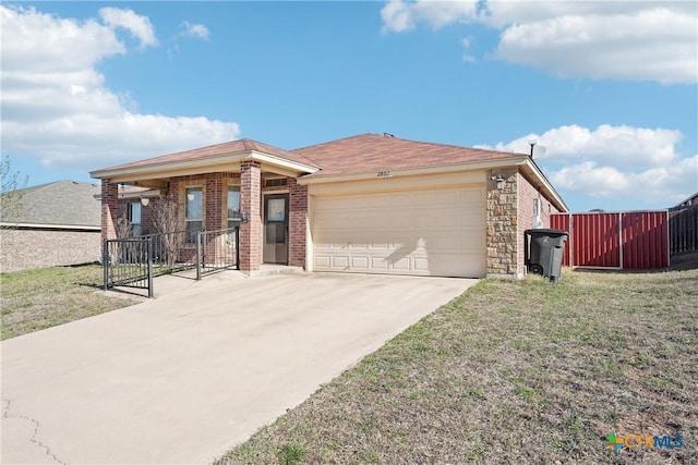 ranch-style house featuring a front lawn, fence, concrete driveway, an attached garage, and brick siding