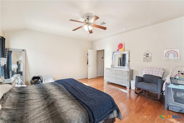 bedroom with visible vents, a ceiling fan, lofted ceiling, and light wood-style floors