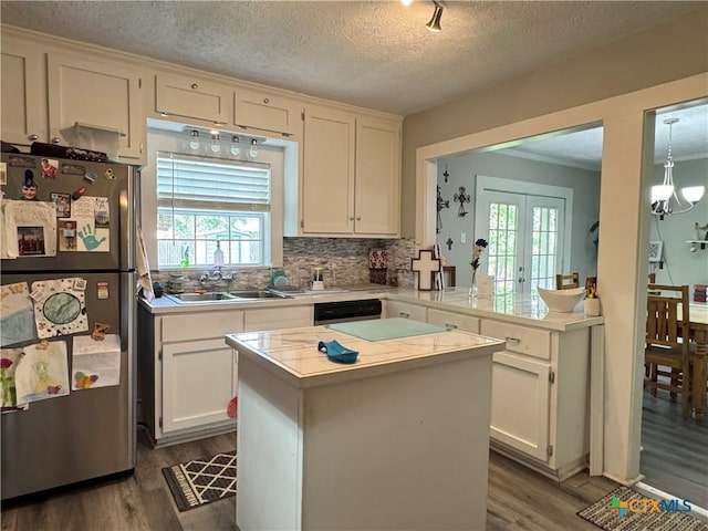1308 E Park Ave, Victoria, TX 77901 - kitchen featuring freestanding refrigerator, a sink, dark wood-style flooring, a kitchen island, and decorative backsplash