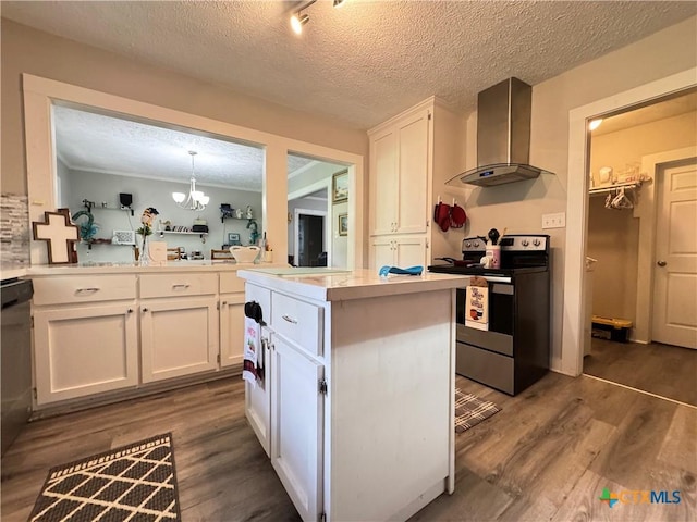 1308 E Park Ave, Victoria, TX 77901 - kitchen featuring wall chimney range hood, appliances with stainless steel finishes, white cabinets, dark wood-type flooring, and light countertops