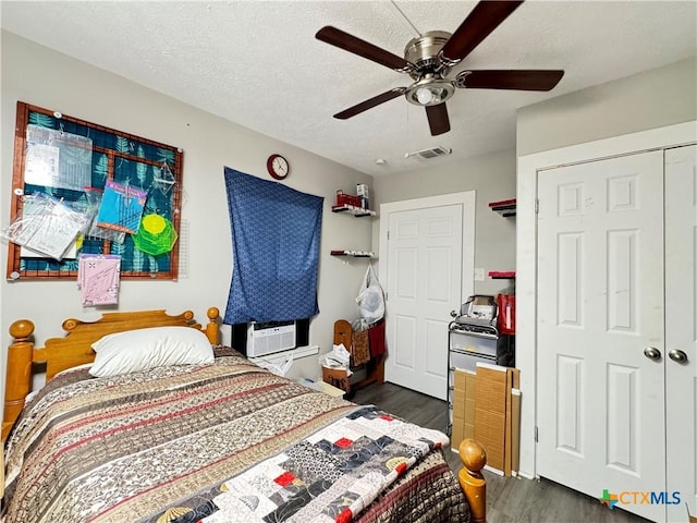 1308 E Park Ave, Victoria, TX 77901 - bedroom featuring dark wood-style flooring, a ceiling fan, cooling unit, a closet, and a textured ceiling