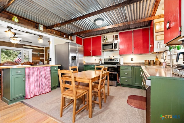 kitchen with stainless steel appliances, sink, ceiling fan, beam ceiling, and light hardwood / wood-style flooring