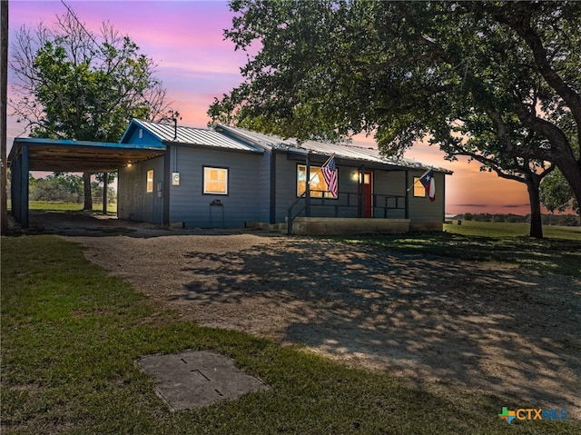 view of front of property with a lawn and a carport