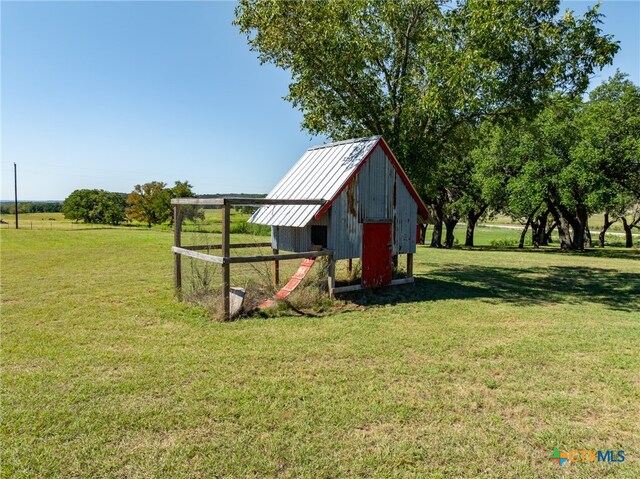 view of outdoor structure with a yard and a rural view