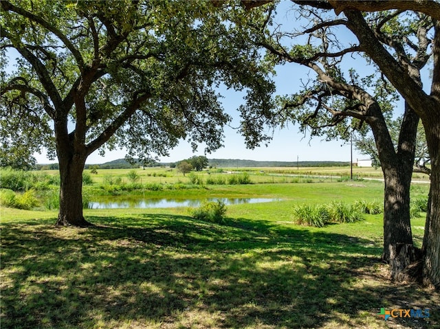 view of yard featuring a rural view and a water view