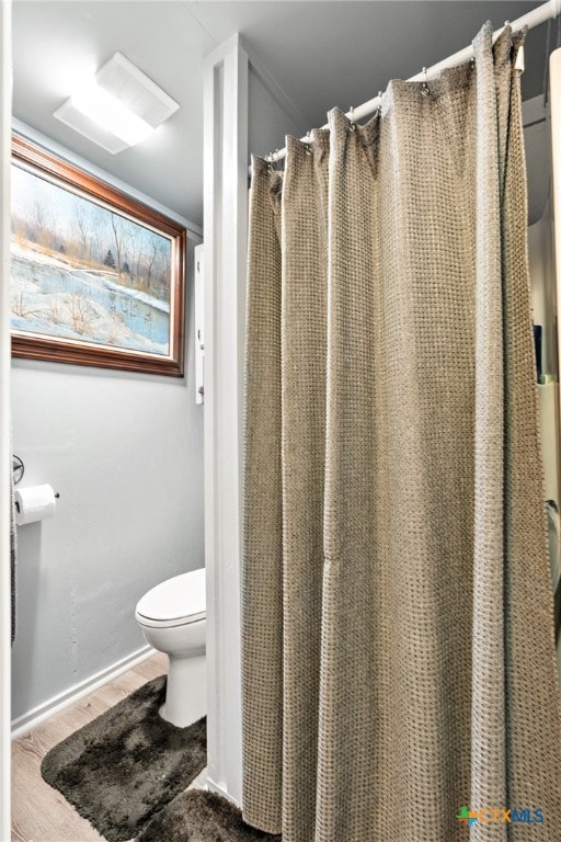 bathroom featuring hardwood / wood-style floors and toilet