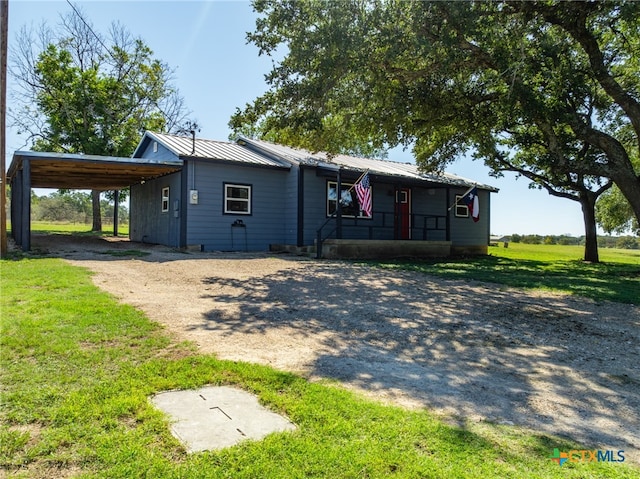 view of front of property featuring a front lawn and a carport