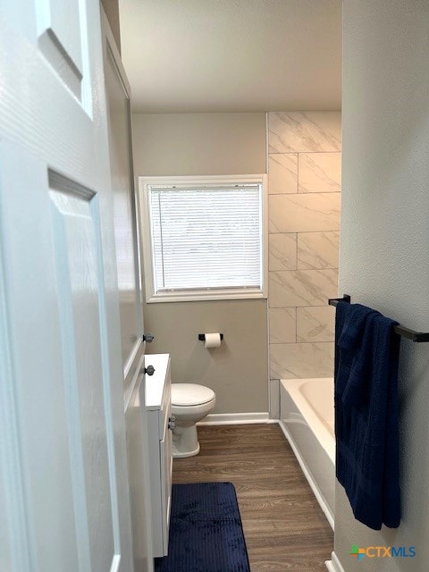 full bathroom featuring tile walls, wood-type flooring, vanity,  shower combination, and toilet