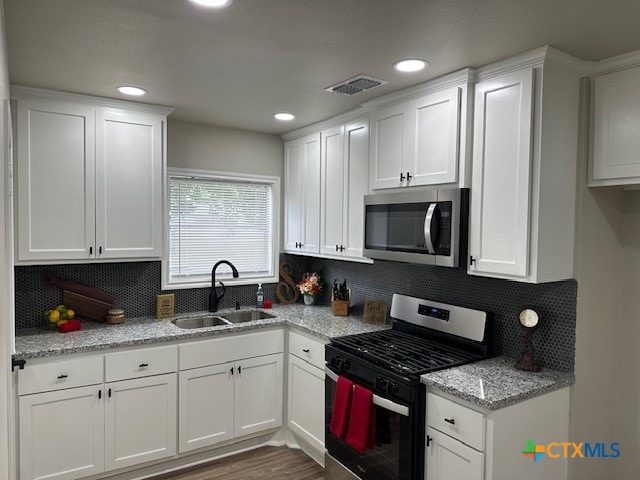 kitchen with white cabinetry, sink, and stainless steel appliances