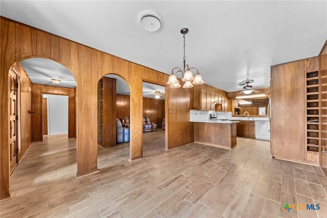 707 Dianne Dr, Copperas Cove, TX 76522 - kitchen featuring a ceiling fan, arched walkways, white dishwasher, wooden walls, and brown cabinetry
