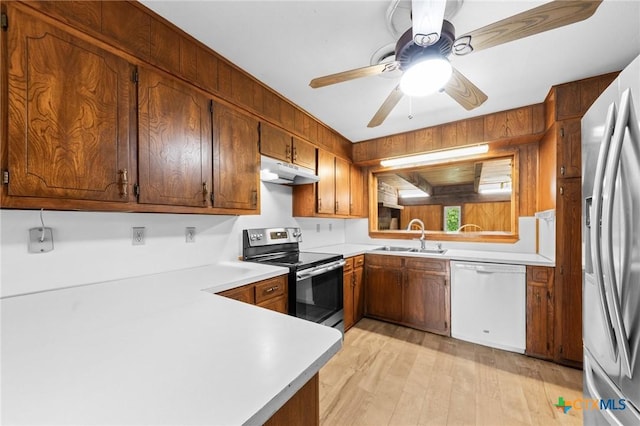 707 Dianne Dr, Copperas Cove, TX 76522 - kitchen featuring appliances with stainless steel finishes, a sink, under cabinet range hood, light countertops, and light wood finished floors