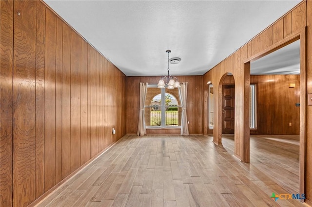 707 Dianne Dr, Copperas Cove, TX 76522 - unfurnished dining area featuring a chandelier, light wood finished floors, and wood walls