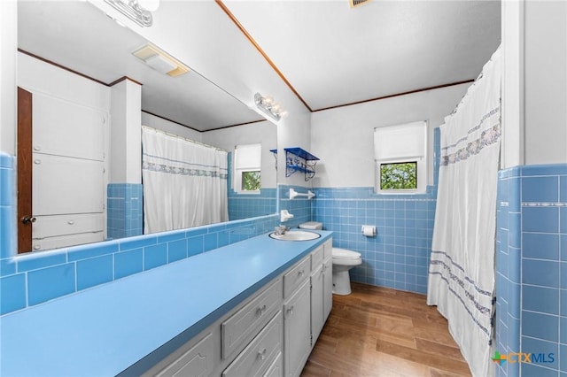 707 Dianne Dr, Copperas Cove, TX 76522 - full bath featuring tile walls, vanity, wood finished floors, toilet, and a wainscoted wall