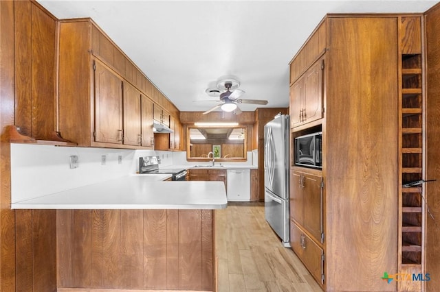 707 Dianne Dr, Copperas Cove, TX 76522 - kitchen with stainless steel appliances, under cabinet range hood, light wood-style floors, a ceiling fan, and a sink