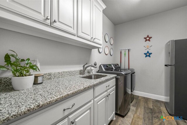 488 Creekside Dr, Belton, TX 76513 - washroom featuring dark wood-style flooring, independent washer and dryer, baseboards, and cabinet space