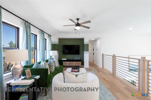 living room featuring a ceiling fan, wood finished floors, and healthy amount of natural light