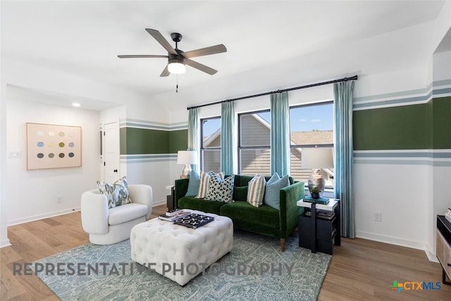 living room with ceiling fan, wood finished floors, and baseboards