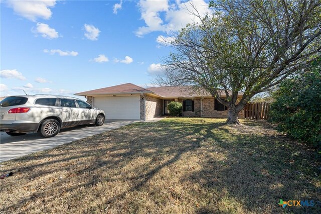 single story home with a garage and a front lawn