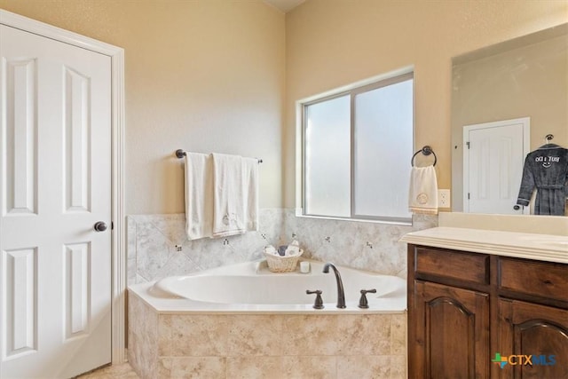 bathroom with vanity and a relaxing tiled tub